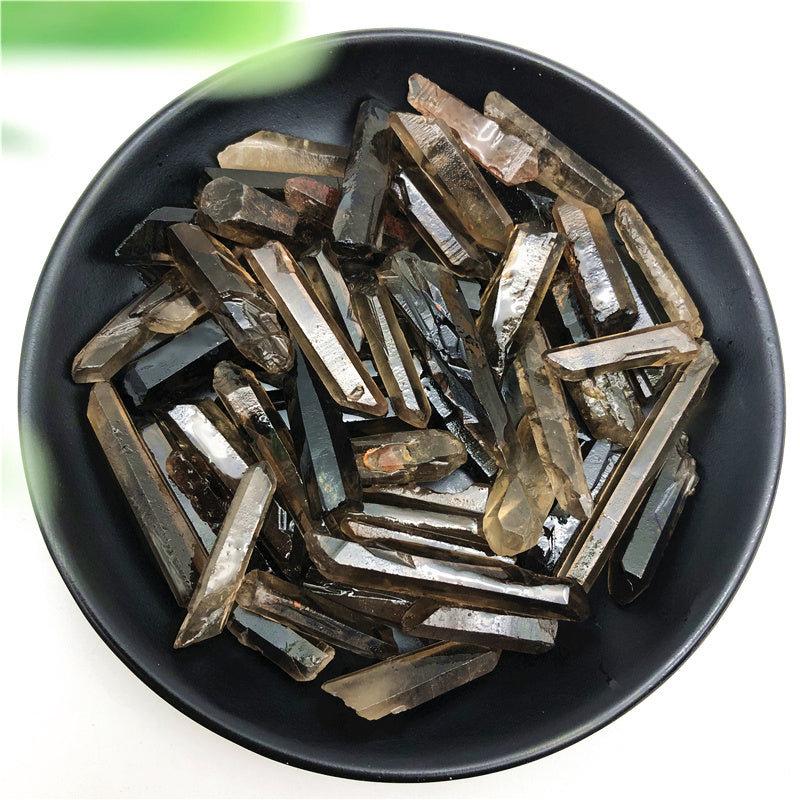 Black bowl filled with metallic objects on a white background