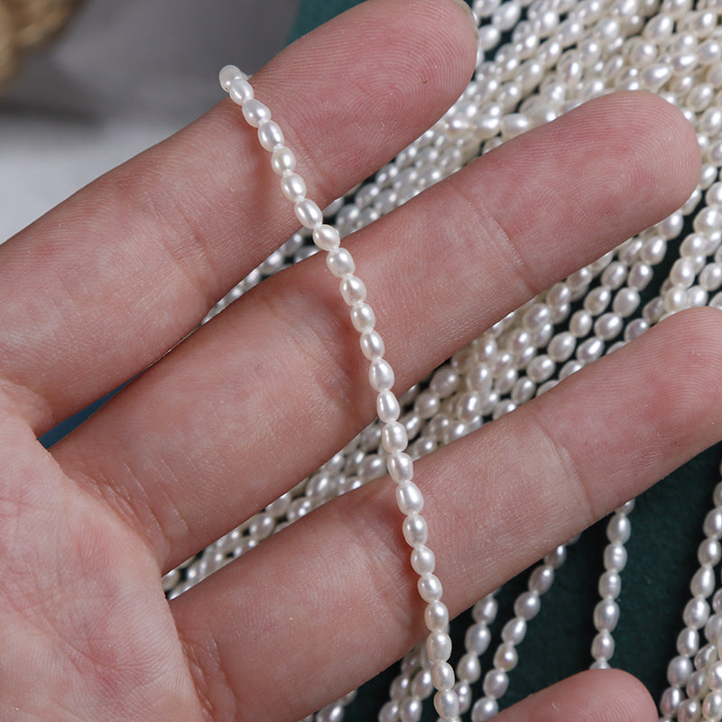 Pearl necklace draped over a hand with a blurred background