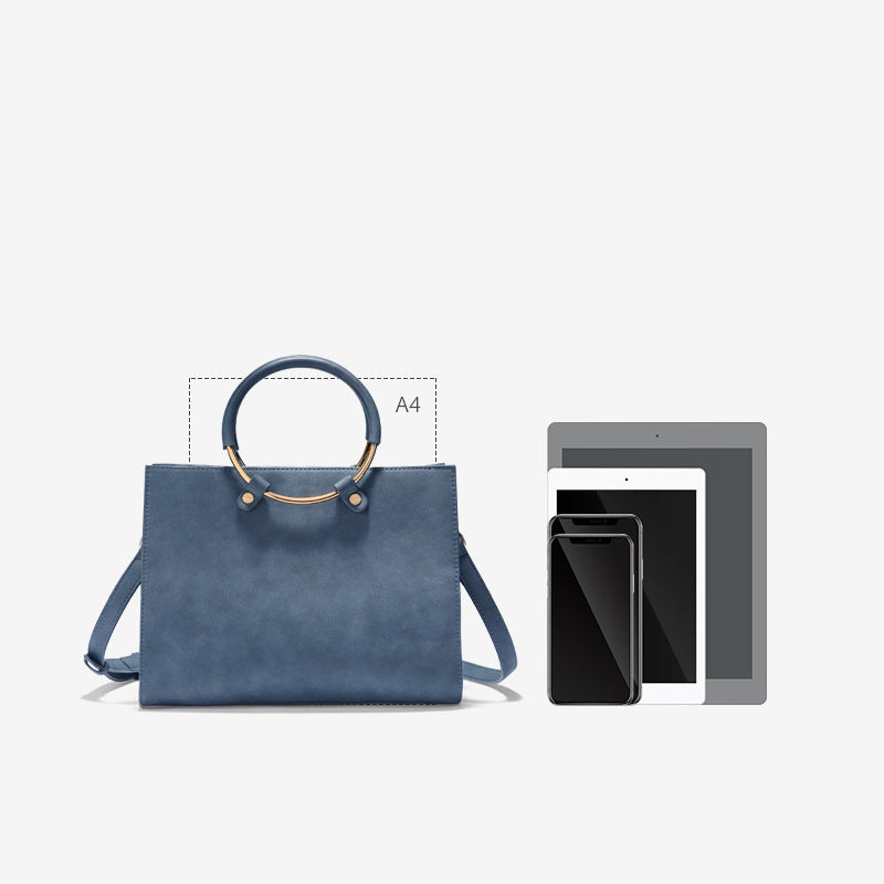 Blue handbag with dimensions indicated and a smartphone and tablet for scale on a white background