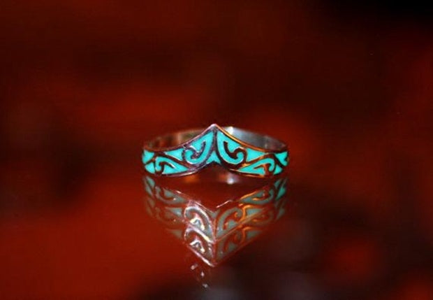 Ring with turquoise and gold design on a dark background