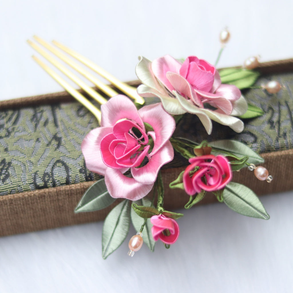 Floral hair comb with pink and white flowers on a decorative background