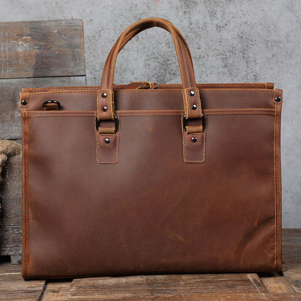 Brown leather briefcase on a wooden surface with a gray concrete wall background