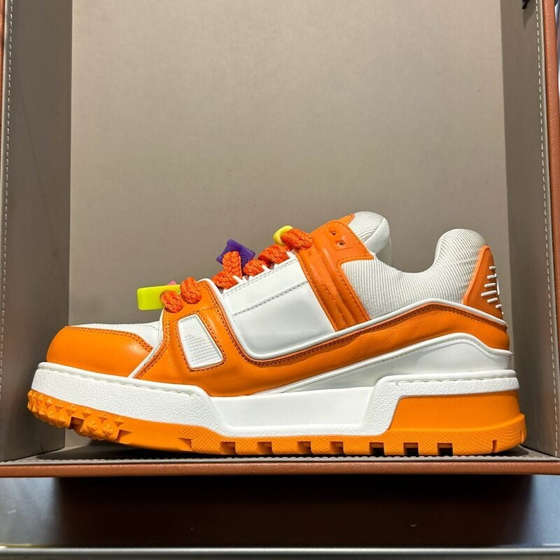 Orange and white sneaker with colorful accents on a neutral background