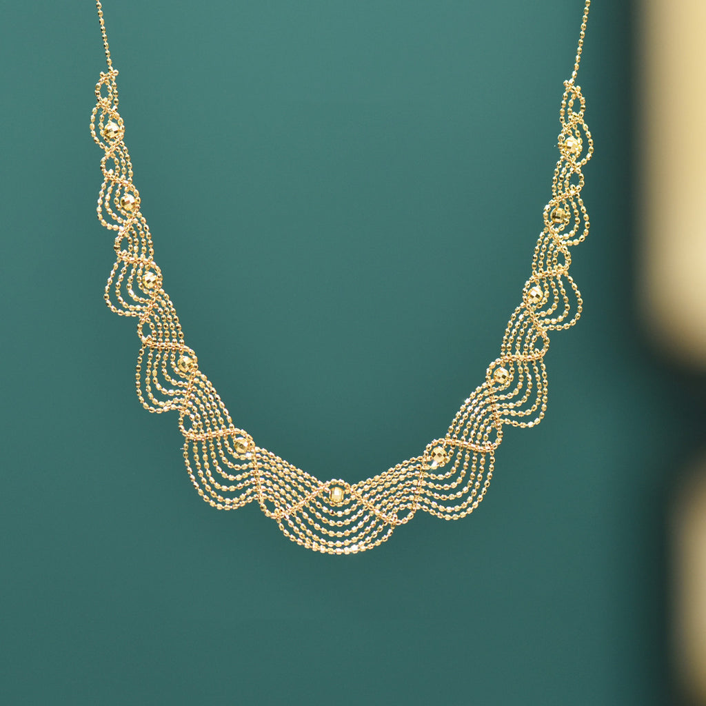 Gold necklace on a teal background
