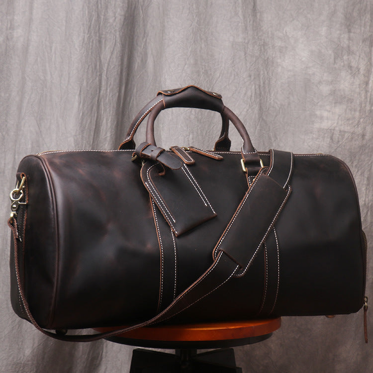 Brown leather duffel bag on a gray background