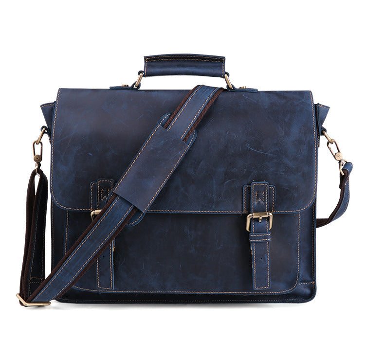 Blue leather satchel bag with a shoulder strap on a white background