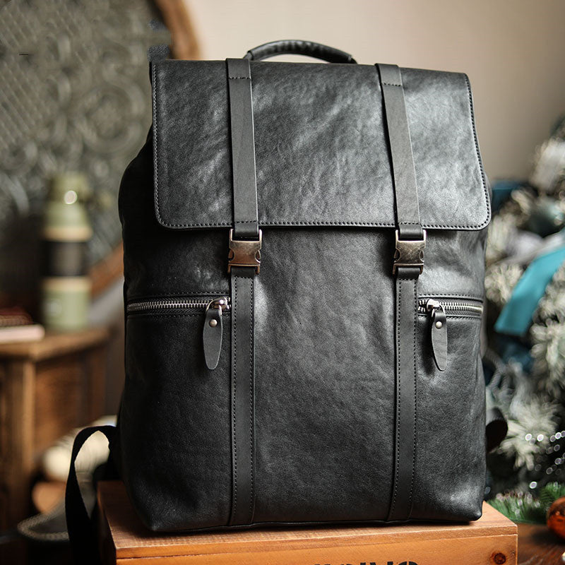Black leather backpack on a wooden surface with a blurred background