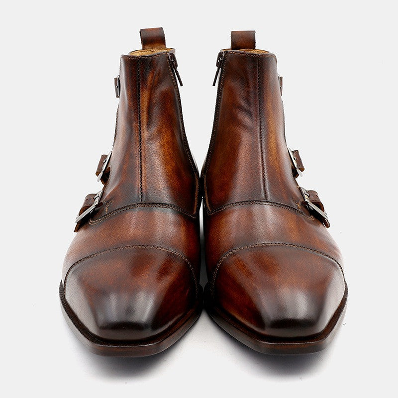 Pair of brown leather boots with buckles on a white background