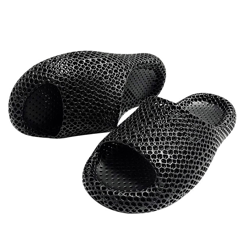 Pair of black textured slippers on a white background