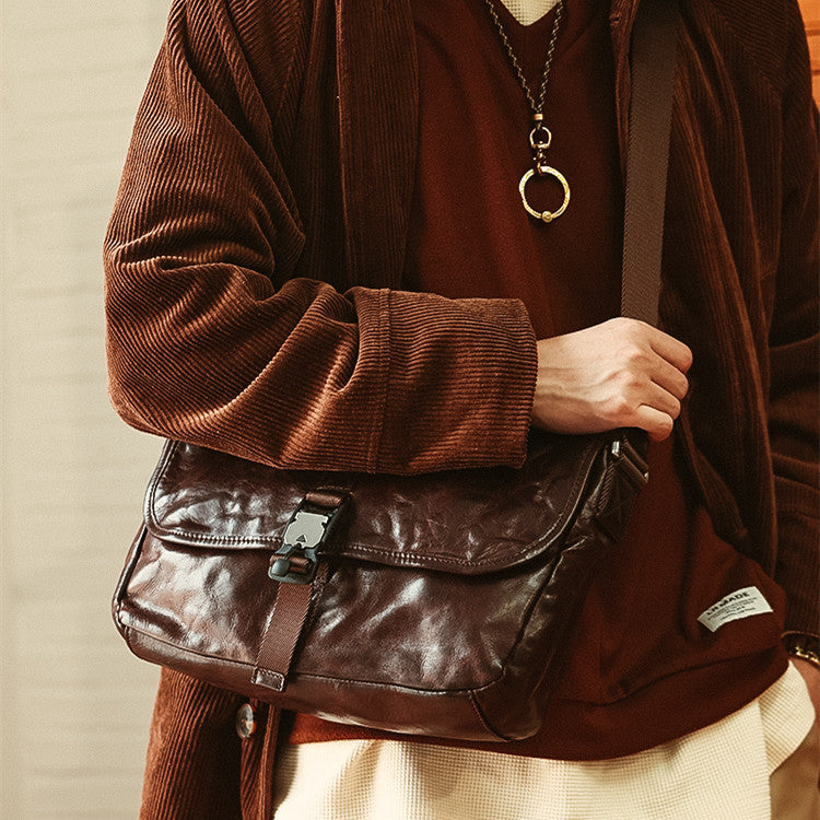 Person wearing a brown leather bag with a neutral background