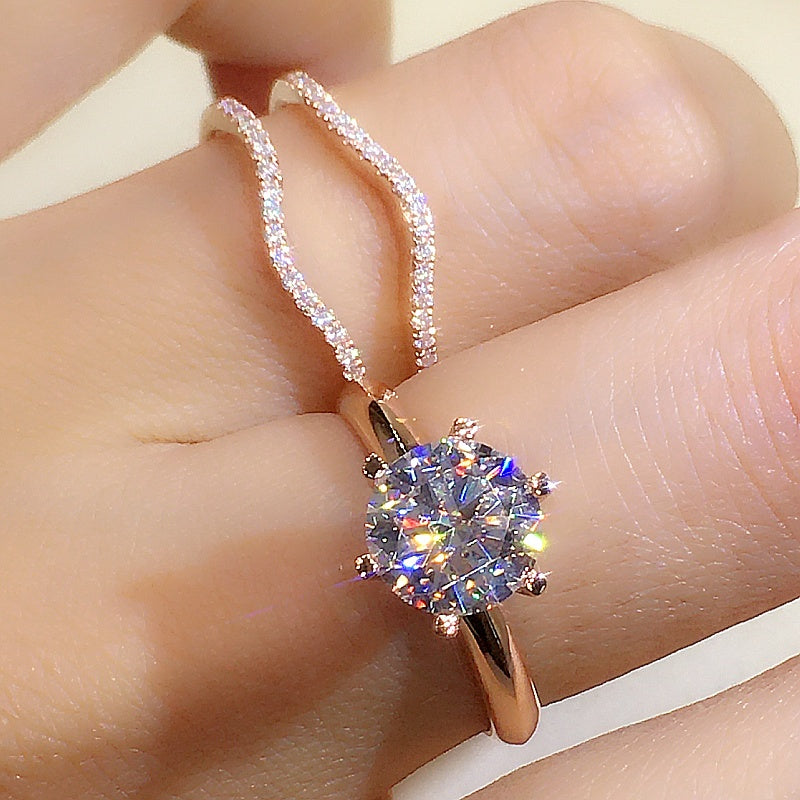 Rose gold ring with a large gemstone on a finger