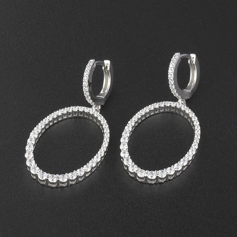 Pair of hoop earrings with clear stones on a black background