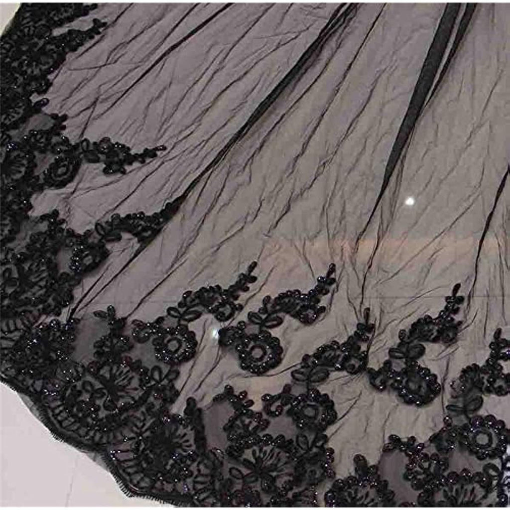 Black lace fabric with bead embellishments on a white background