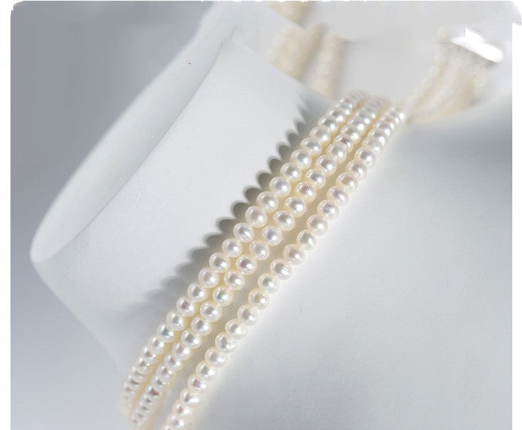 Three pearl necklaces on a white surface