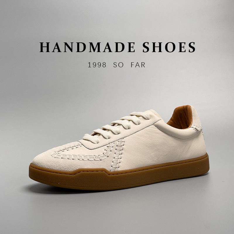 White sneaker with brown sole on a gray background, labeled 'Handmade Shoes'.