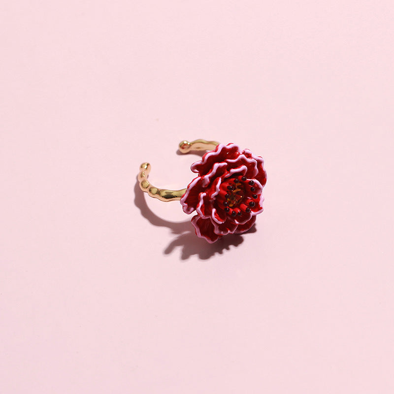 Red flower-shaped earring on a pink background