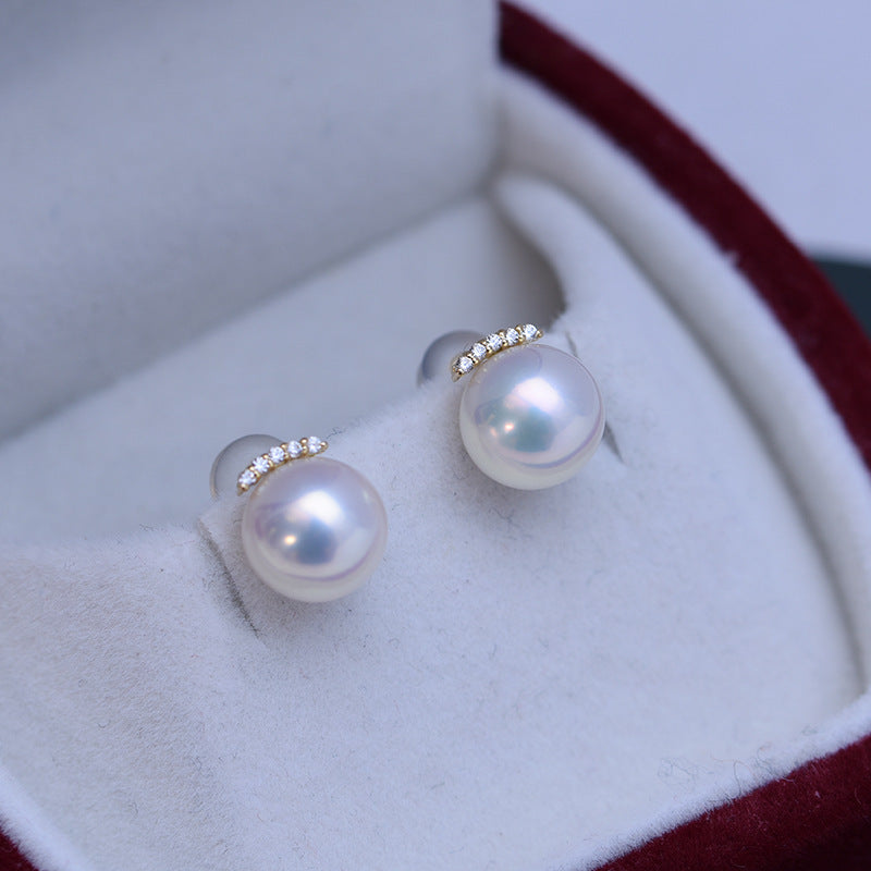 Pearl earrings with gold accents in a jewelry box