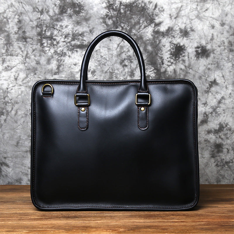 Black leather briefcase on a wooden surface with a gray textured background