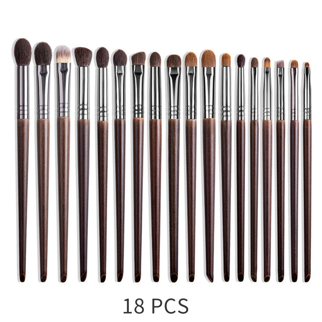Set of 18 makeup brushes with brown handles and silver ferrules on a white background.