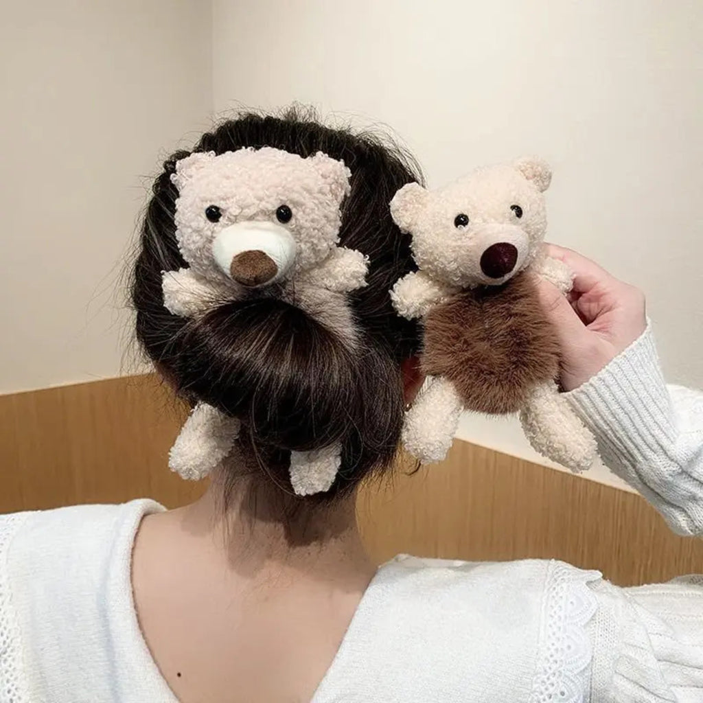 Person with teddy bear hair accessories in their hair against a neutral background