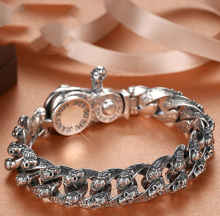 Silver bracelet with intricate design on a beige fabric background