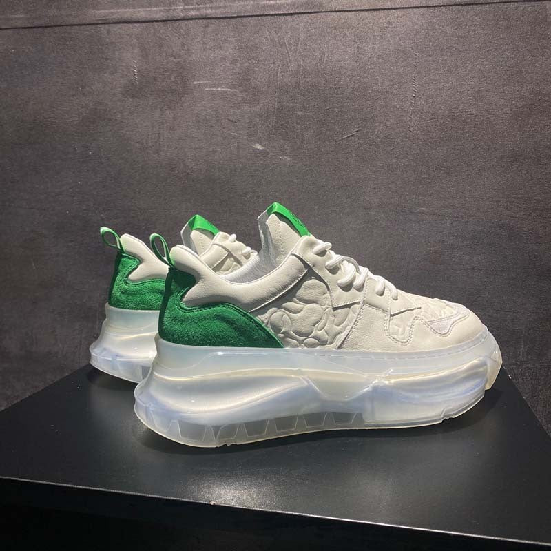 White and green sneakers on a dark surface with a gray background