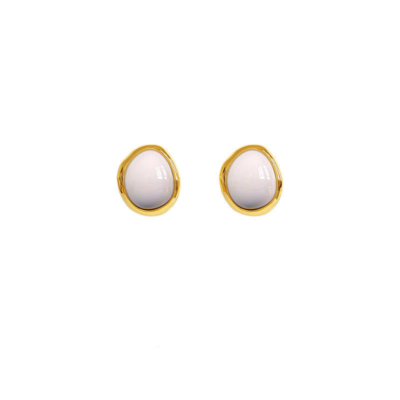 Pair of gold-framed earrings with white stones on a white background