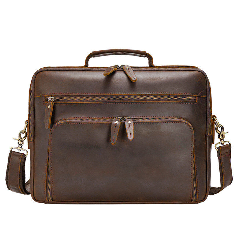 Brown leather briefcase with multiple pockets and zippers on a white background