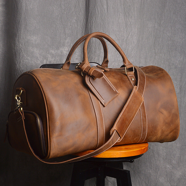 Brown leather duffel bag on a gray background