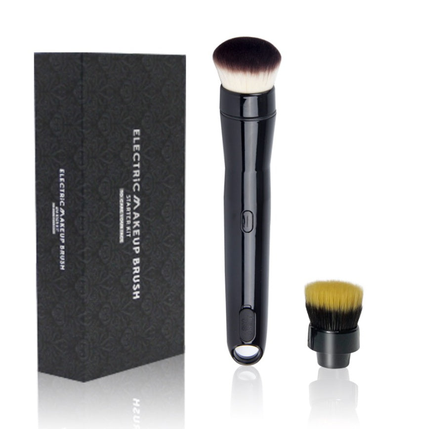 Electric makeup brush with black handle and brown bristles next to its packaging on a white background