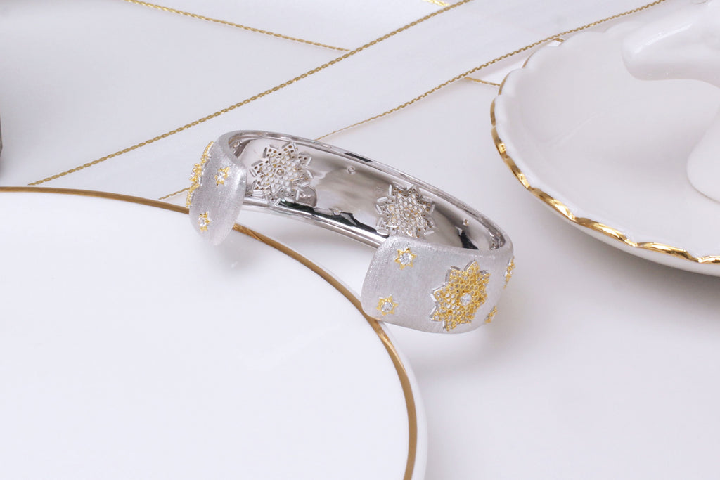 Silver ring with gold accents on a white surface