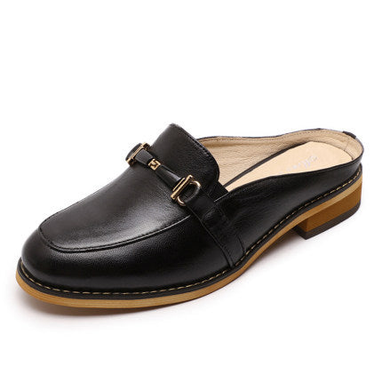 Black loafer shoe with a brown sole on a white background