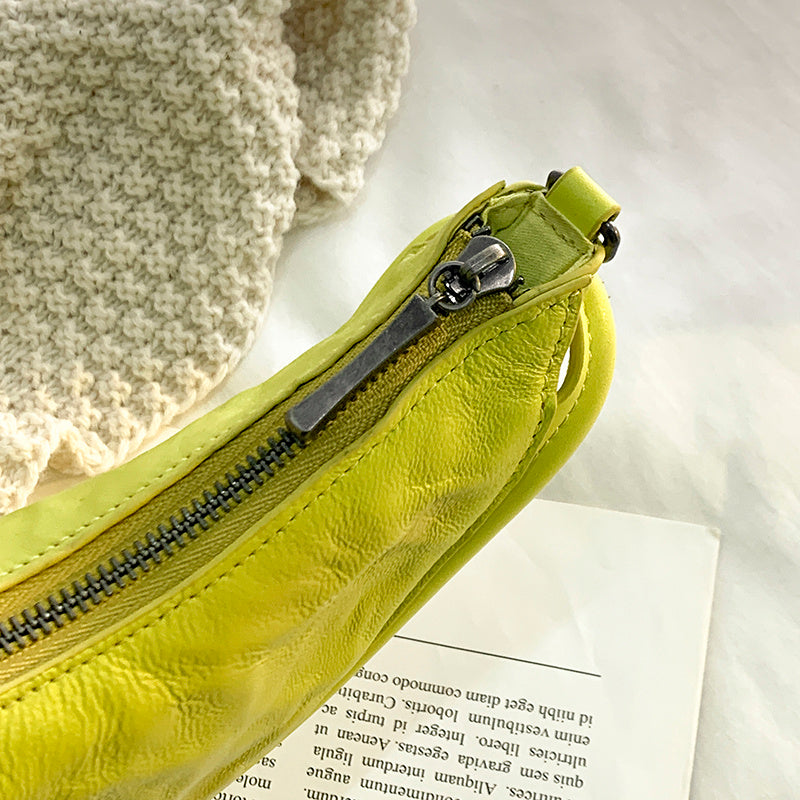 Yellow textured pouch with a zipper on a white surface