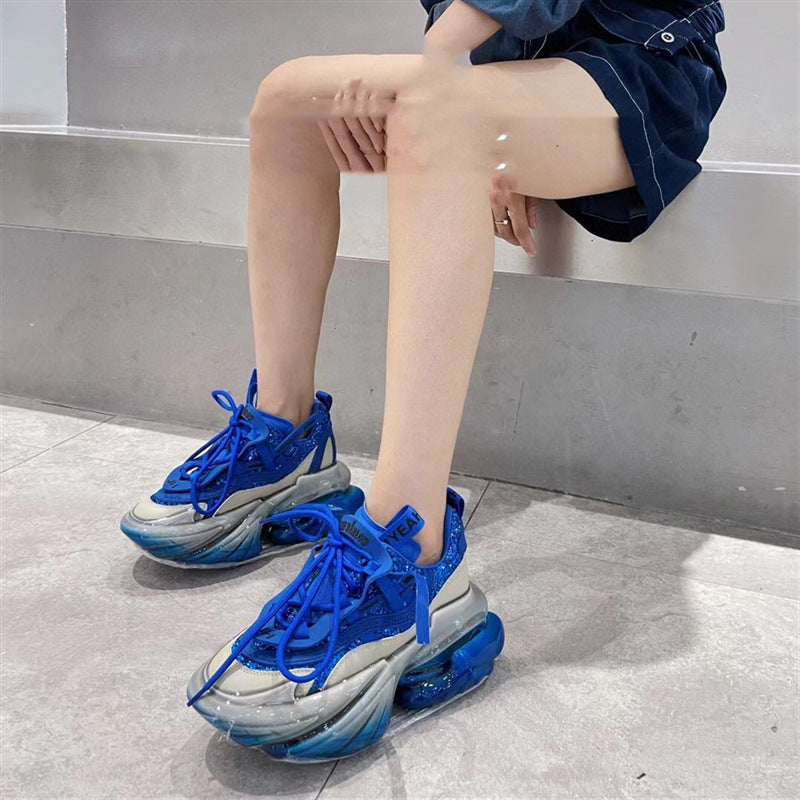 Person wearing blue and gray sneakers sitting on a bench.