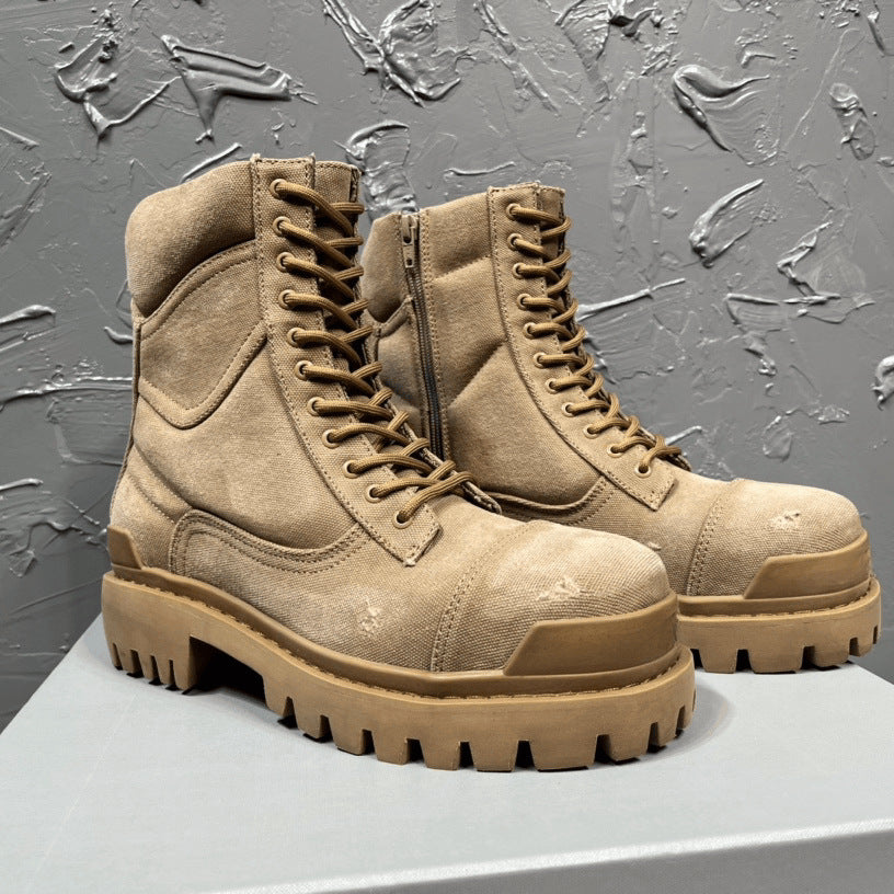 Pair of tan boots with thick soles on a textured gray background