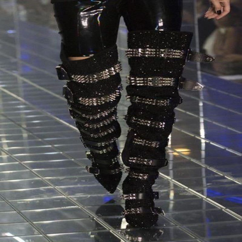 Black studded knee-high boots on a reflective floor