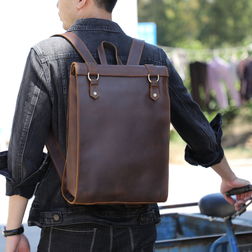 Person wearing a brown leather backpack outdoors