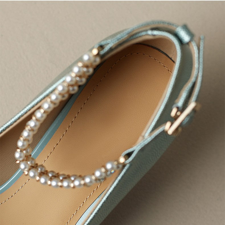 Light blue shoe with pearl embellishments on a beige background