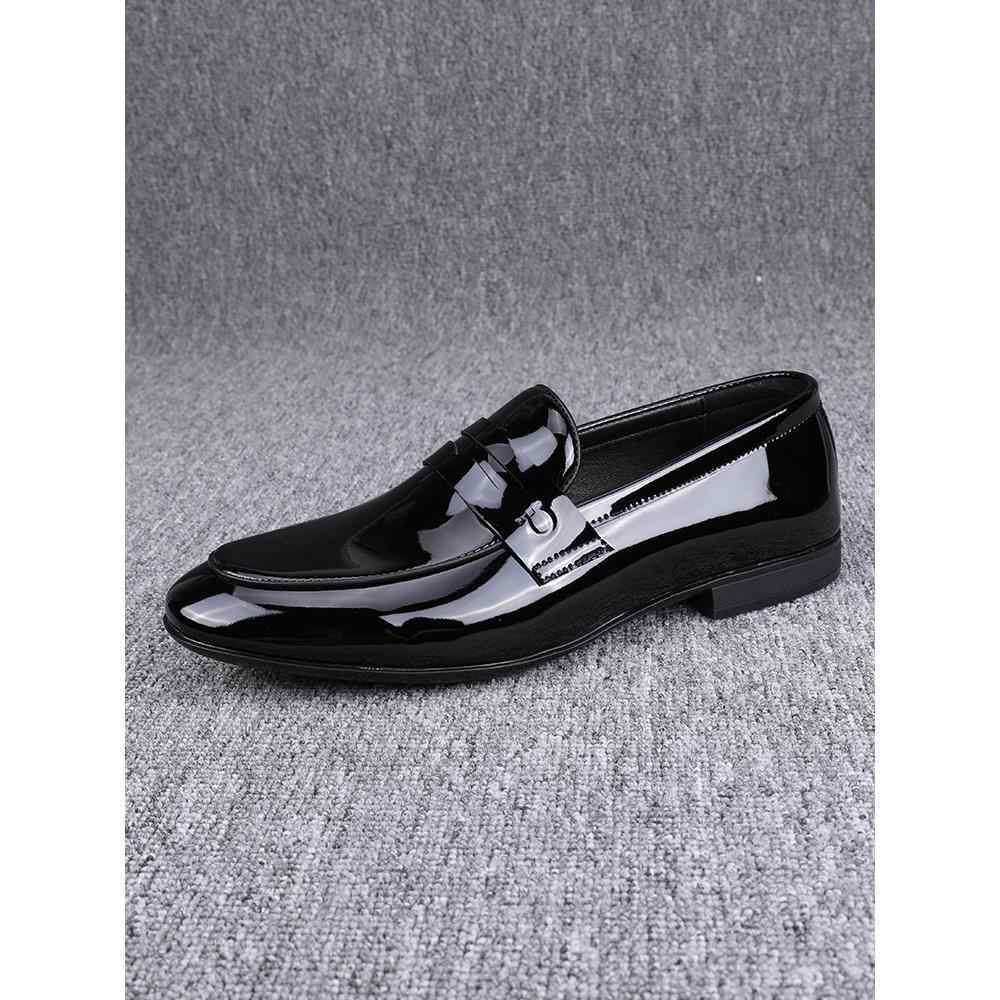 Black glossy loafer shoe on a gray textured background