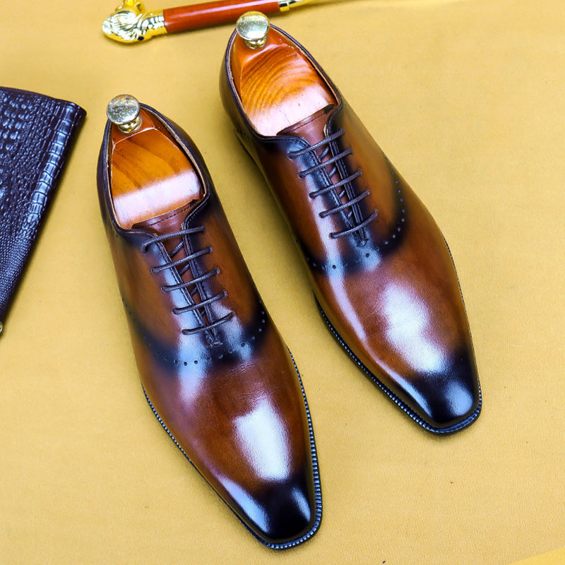 Pair of brown leather dress shoes on a beige surface
