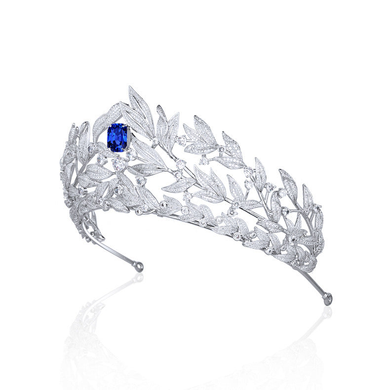 Silver tiara with a blue gemstone on a white background
