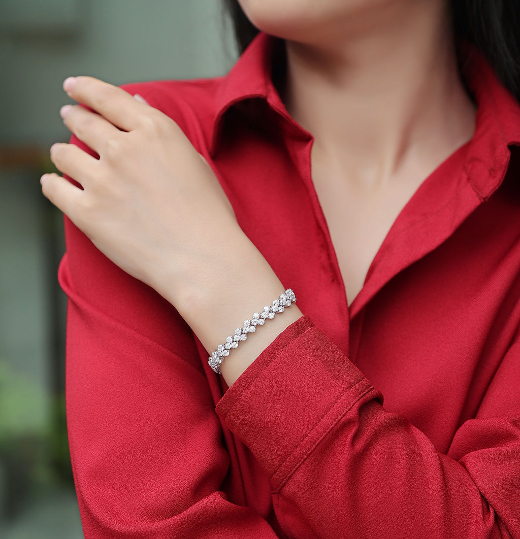 Person wearing a red shirt with a silver bracelet on a blurred background