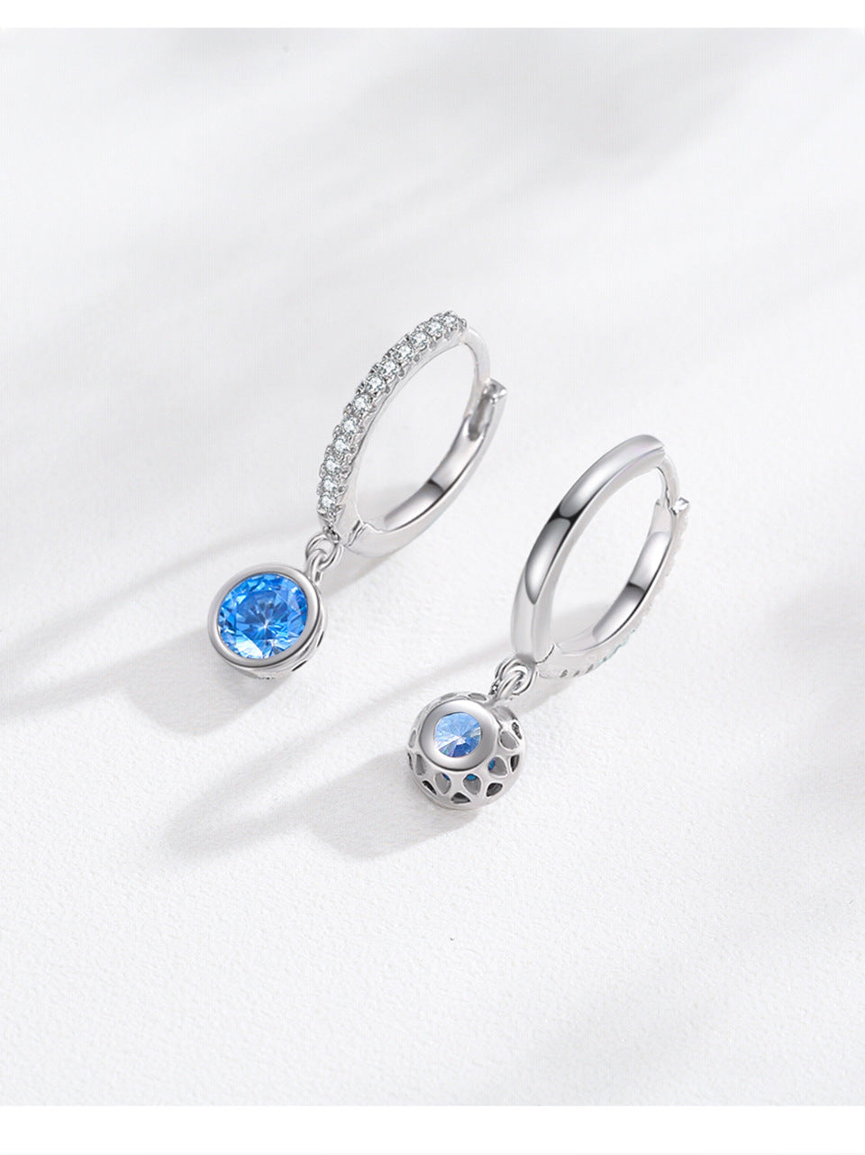 Pair of silver earrings with gemstones on a white background