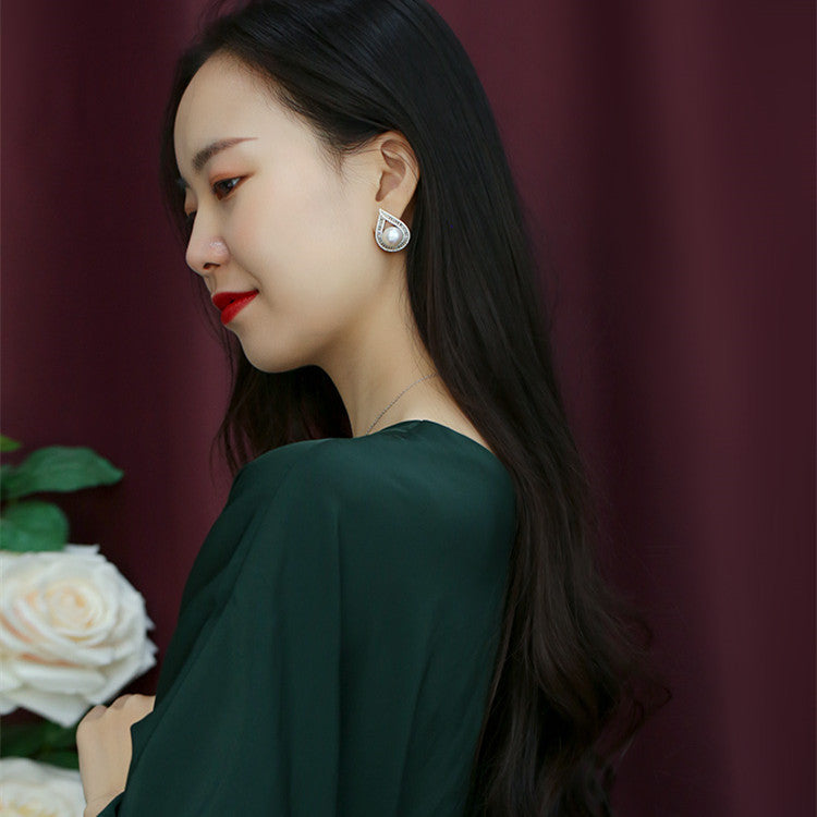 Woman wearing pearl earrings with a blurred background