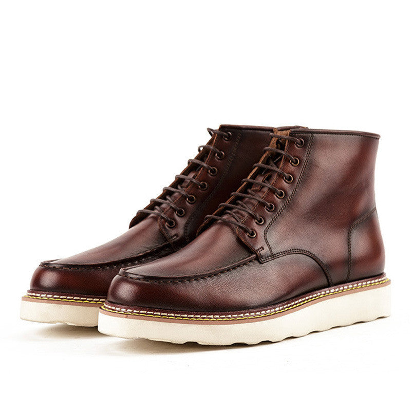 Pair of brown leather boots with white soles on a white background