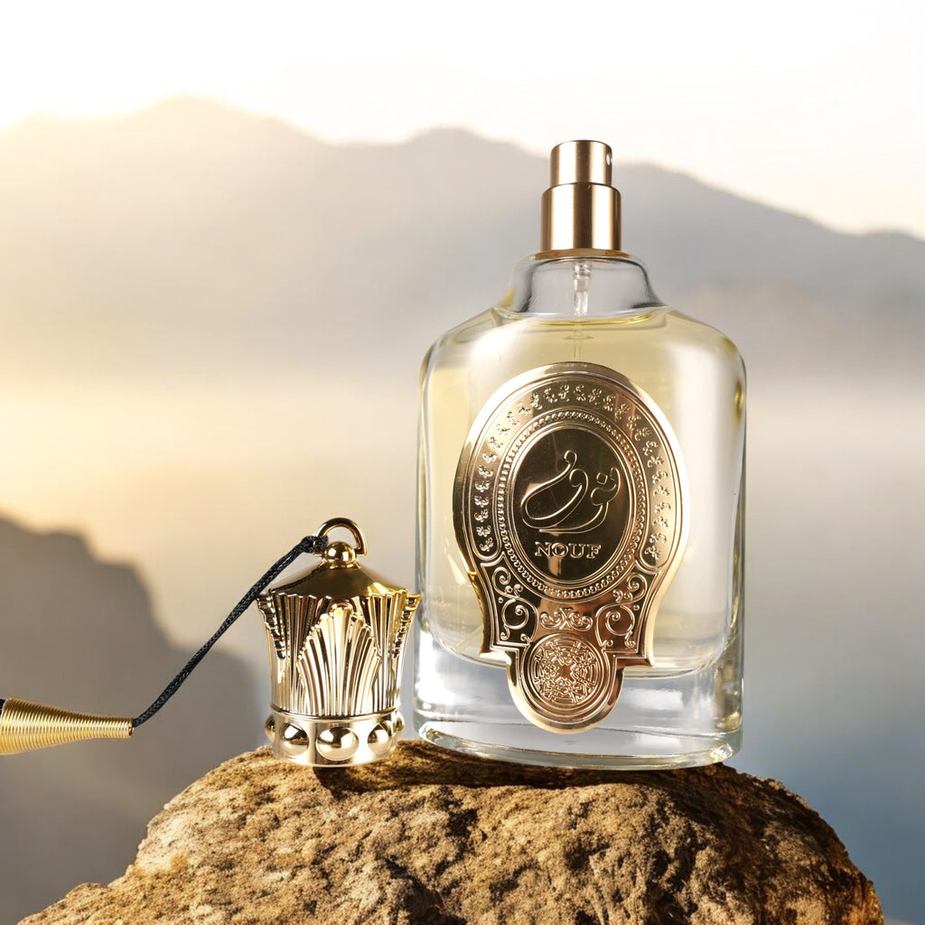 Perfume bottle with gold cap and decorative label on a rock with soft background