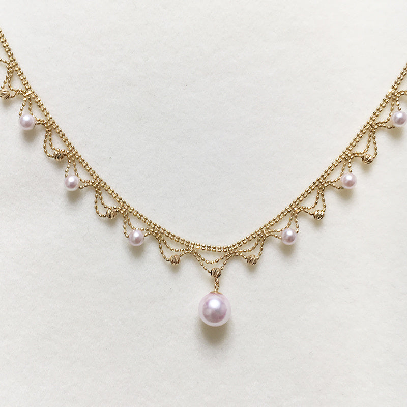 Gold necklace with pearls on a light background