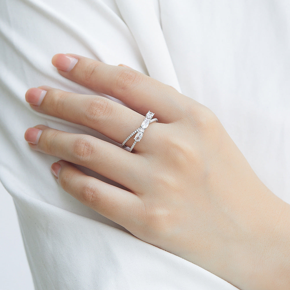 Hand wearing a silver ring with a diamond on a white background