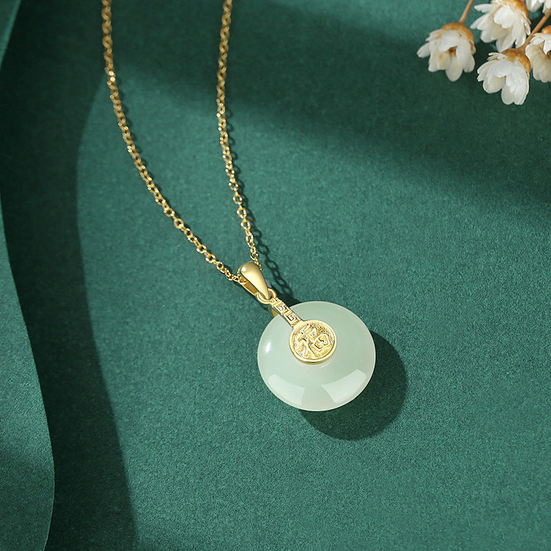 Gold necklace with a green jade pendant on a green background