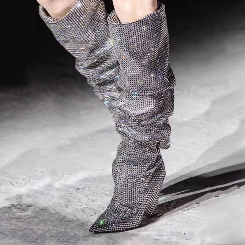 Silver rhinestone knee-high boots on a neutral background